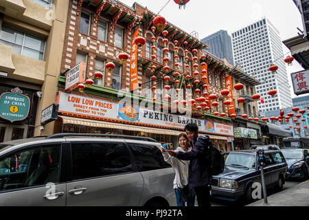 Un couple posent pour une à l'extérieur de la Peking Bazar selfies à San Francisco's iconic Chinatown quartier. Banque D'Images