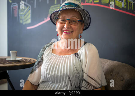 Vieille femme élégante de boire du café au café place Banque D'Images