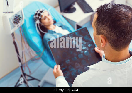 Homme travailleur de laboratoire l'analyse irm pendant la procédure de l'électroencéphalographie Banque D'Images