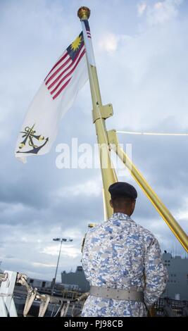 PEARL HARBOR (7 juillet 2018) Un marin malaisien s'abaisse le drapeau à bord de la couleurs au cours de la frégate de la marine royale malaisienne KD Lekiu (FFG 30), au cours d'une réception tenue le Joint Base Pearl Harbor-Hickam au cours de Rim of the Pacific, le 7 juillet. Vingt-cinq nations, 46 navires, 5 sous-marins, environ 200 avions et 25 000 personnes participent à l'EXERCICE RIMPAC du 27 juin au 2 août dans et autour des îles Hawaï et la Californie du Sud. Le plus grand exercice maritime international RIMPAC, fournit une formation unique alors que la promotion et le soutien de relations de coopération entre les participants Banque D'Images