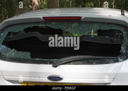 Ford Fiesta blanche voiture avec pare-brise arrière défoncé dans un parking forestiers Banque D'Images