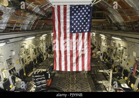 Le drapeau américain est accroché un toit en Caroline Air National Guard C-17 Globemaster III, tandis que les membres de la 156e Escadron d'évacuation aéromédicale (AES) préparez-vous au décollage en arrière-plan, au North Carolina Air National Guard Base, Charlotte Douglas International Airport, le 9 juillet 2018. Les jours vol est la première mission pour l'NCANG et exploite les membres du 156e Escadron d'évacuation aéromédicale à un exercice d'entraînement hors de l'état. Banque D'Images