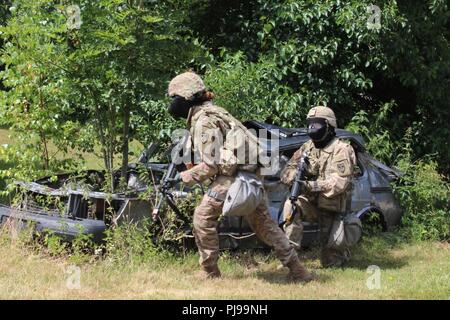 Le Sgt. Shuntaneque Greenwald, l'OTAN, l'armée américaine Brigade limites pour couvrir comme son partenaire couvre sa au cours de la 21e meilleur guerrier commande Soutien Théâtre de la situation de concurrence d'entraînement lane à Baumholder, Allemagne le 9 juillet. Greenwald et 17 autres concurrents ont été chargés d'évasion et de tir direct et indirect l'évacuation des pertes au cours de la STX lane. Banque D'Images
