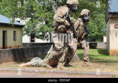 Le Sgt. Goehle Nelson, 18e Brigade de police militaire, et le Sgt. Shuntaneque Greenwald, U.S. Army NATO Brigade, évacuer une victime simulée à la sécurité lors de la 21e soutien Théâtre de la situation Commande d'entraînement à Baumholder, Allemagne le 9 juillet. Goehle et Greenwald avec 16 autres concurrents ont été chargés d'évasion et de tir direct et indirect l'évacuation des pertes au cours de la STX lane. Banque D'Images