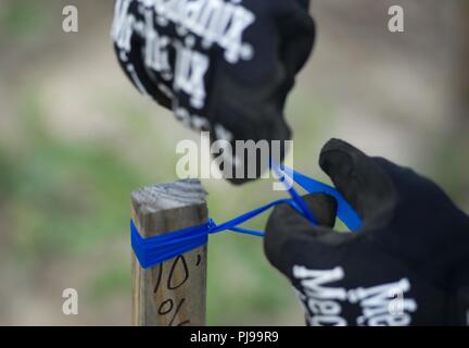 Un membre de la 166e Escadron de génie civil, New York Air National Guard, sondage liens autour d'un jeu de bandes d'altitude pour le drainage des eaux pluviales dans le cadre de la première phase de la construction du camp Kamassa dans Crystal Springs, Mississippi, le 9 juillet 2018. Kamassa Camp sera le membres premier entièrement accessible aux personnes handicapées, à l'année installation de camp pour les enfants et adultes ayant des besoins spéciaux, qui se construit sur 326 hectares mené par le ministère de la défense de l'état de préparation du programme de formation novateur. Banque D'Images