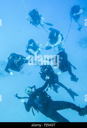 AQABA, Jordanie (8 juillet 2018) Les Marines américains avec Raid Maritime Force (MDL), 26e Marine Expeditionary Unit (MEU), et des membres de la Marine Royal Jordanian nager sous l'eau pendant la formation de plongée à Aqaba, Jordanie, 8 juillet 2018. Iwo Jima est déployé sur le 5e flotte américaine zone d'opérations à l'appui des opérations navales pour assurer la stabilité et la sécurité maritime dans la région centrale, reliant la Méditerranée et le Pacifique à travers l'ouest de l'Océan indien et trois points d'étranglement stratégiques. Banque D'Images