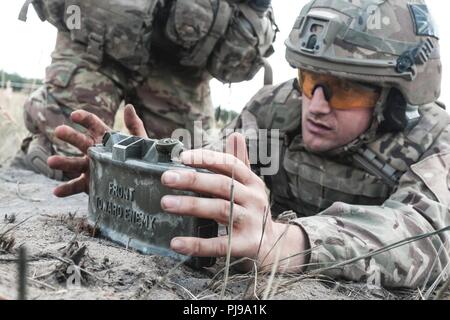 Royaume-uni Le Sgt. Rob Veasey, un sergent de troupe avec 1ère la reine Dragoon Guards, emplaces M18A1 au cours d'une mine Claymore claymore multinationales d'entraînement avec le groupe de combat en Pologne Bemowo Piskie Domaine de formation, la Pologne le 10 juillet 2018. La Pologne est un groupe de combat, unique coalition multinationale d'États-Unis, Royaume-Uni, croate et soldats roumains qui servent avec la 15e Brigade mécanisée polonaise comme une force de dissuasion de l'OTAN à l'appui de l'amélioration de l'avant la Présence. Banque D'Images