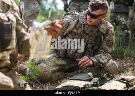 La CPS. Andrew Gipson, un mobile, en Alabama et indigènes fantassin 1er Escadron, 2e régiment de cavalerie, dépaquète M18A1 Claymore mines pendant un exercice multinational de formation claymore avec Battle Group Pologne Bemowo Piskie au domaine de formation, la Pologne le 10 juillet 2018. La Pologne est un groupe de combat, unique coalition multinationale d'États-Unis, Royaume-Uni, croate et soldats roumains qui servent avec la 15e Brigade mécanisée polonaise comme une force de dissuasion de l'OTAN à l'appui de l'amélioration de l'avant la Présence. Banque D'Images