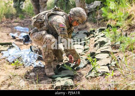 La CPS. Camden Bowers, un Blue Earth, Minnesota et indigènes fantassin 1er Escadron, 2e régiment de cavalerie, dépaquète M18A1 Claymore mines pendant un exercice multinational de formation claymore avec Battle Group Pologne Bemowo Piskie au domaine de formation, la Pologne le 10 juillet 2018. La Pologne est un groupe de combat, unique coalition multinationale d'États-Unis, Royaume-Uni, croate et soldats roumains qui servent avec la 15e Brigade mécanisée polonaise comme une force de dissuasion de l'OTAN à l'appui de l'amélioration de l'avant la Présence. Banque D'Images