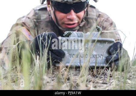 Un soldat de l'armée américaine avec 1er Escadron, 2e régiment de cavalerie, un emplaces M18A1 au cours d'une mine Claymore claymore multinationales d'entraînement avec le groupe de combat en Pologne Bemowo Piskie Domaine de formation, la Pologne le 10 juillet 2018. La Pologne est un groupe de combat, unique coalition multinationale d'États-Unis, Royaume-Uni, croate et soldats roumains qui servent avec la 15e Brigade mécanisée polonaise comme une force de dissuasion de l'OTAN à l'appui de l'amélioration de l'avant la Présence. Banque D'Images