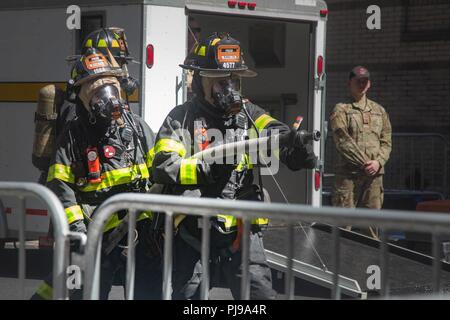 Les pompiers avec le New York City Fire Department (FDNY) prépare sa lance à incendie comme ils s'entraînent aux côtés des soldats de l'Armée américaine sur la façon de répondre à une urgence à grande échelle à New York City, New York, le 10 juillet 2018. Le FDNY le long de l'armée américaine avec l'armée américaine et du Commandement du Nord est la réalisation d'un exercice conjoint simulant un incident chimique, biologique, radiologique et nucléaire (CBRN) Événement pour maximiser la réponse appropriée à partir de la première réponse. Banque D'Images