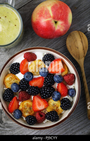 Petit-déjeuner utile de fromage cottage, crème aigre et baies diverses avec des fruits. Vue de dessus Banque D'Images