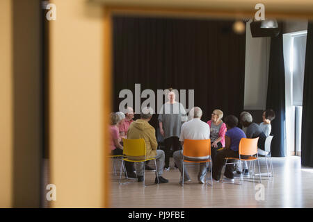 Personnes âgées du groupe leader femme discussion dans community centre Banque D'Images