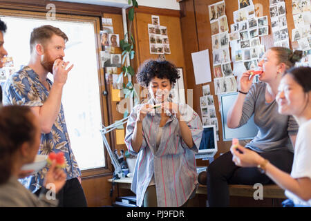 Creative business people eating in office Banque D'Images