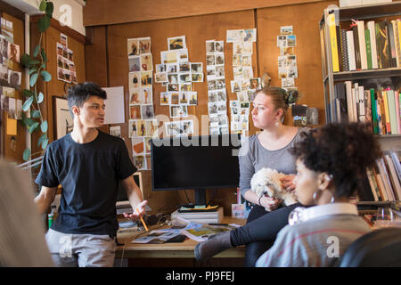 Creative designers with dog sitting in office Banque D'Images