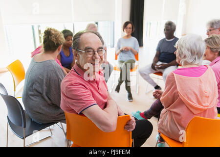 Portrait happy active senior man réunion avec un groupe en cercle dans un centre communautaire Banque D'Images