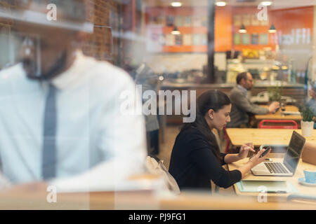 L'accent businesswoman working at laptop in cafe Banque D'Images