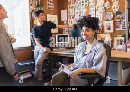 Portrait souriant, confiant femelle créatif designer with digital tablet in office Banque D'Images