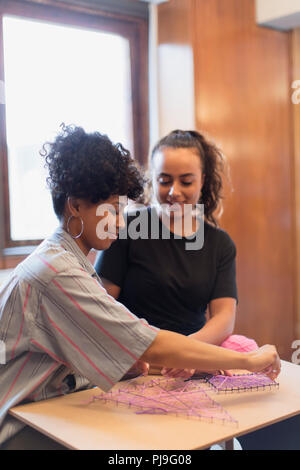 Smiling women doing string art project Banque D'Images