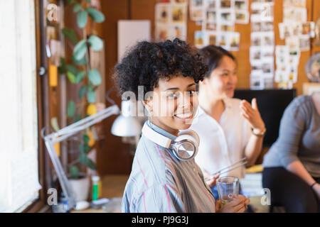 Portrait souriant, confiant creative businesswoman with headphones in office Banque D'Images