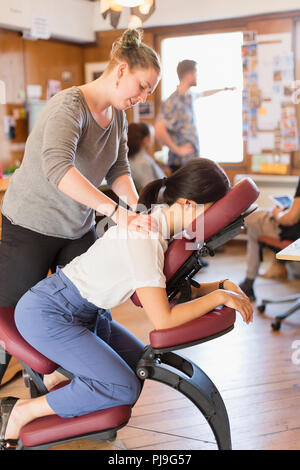 Creative businesswoman receiving massage masseuse de in office Banque D'Images