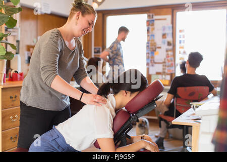 Creative businesswoman receiving massage masseuse de in office Banque D'Images