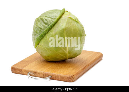 Tête de chou vert sur la planche à découper en bois blanc avec fond isolé. Ingrédients pour la nourriture végétarienne. Banque D'Images