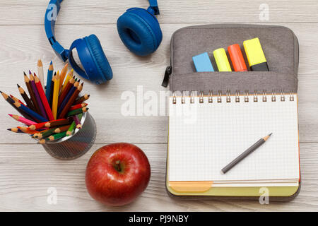 Les fournitures scolaires. Support métallique pour Apple, avec des crayons de couleur aquarellables, écouteurs, ouvrez un livre d'exercices sur-sac à crayons de couleur feutres et marqueurs Banque D'Images