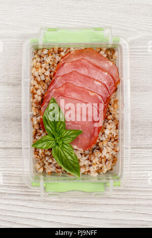 Préparation des repas en plastique contenant avec sarrasin bouilli de porridge et de tranches de viande. Vue d'en haut Banque D'Images