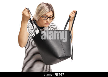 Jeune femme avec des lunettes à la recherche de quelque chose dans son sac à main isolé sur fond blanc Banque D'Images