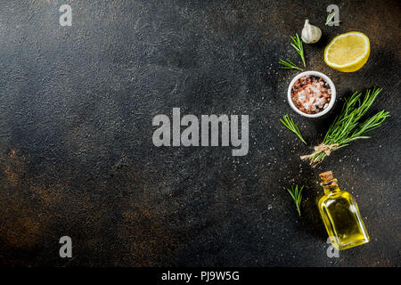 Arrière-plan de cuisson ingrédients alimentaires. Les épices, l'ail, les herbes, l'huile d'olive. rusty black table en pierre. Au-dessus de l'espace de copie Banque D'Images