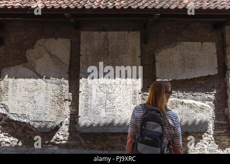 Cité médiévale de Tallinn, vue arrière d'un touriste regardant une exposition de pierres tombales médiévales dans Katarina kaik dans la vieille ville de Tallinn, Estonie Banque D'Images