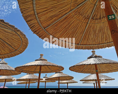 Parasols avec ciel bleu sur la plage, maison de vacances Banque D'Images