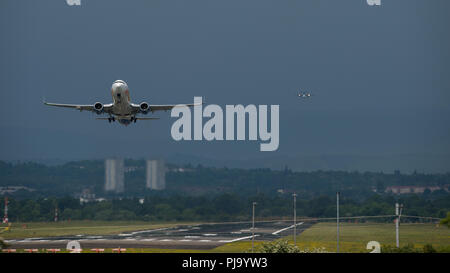 Jet2 Airlines Jet vu au loin dans un ciel d'orage de l'Aéroport International de Glasgow, Renfrewshire, en Écosse. Banque D'Images