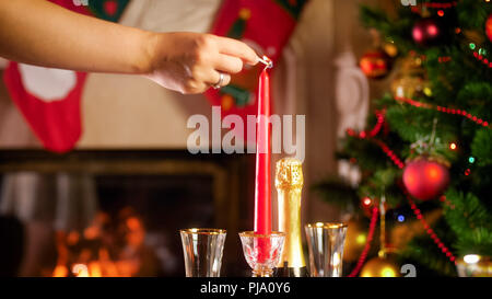 Image Gros plan femme jeune d'allumer une bougie sur une table de Noël Banque D'Images