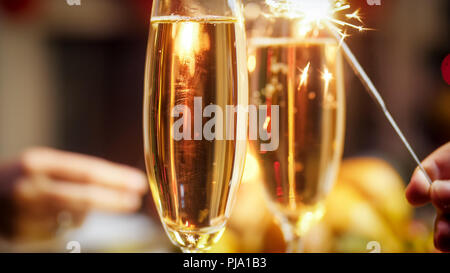 Photo gros plan de deux personnes célébrer Noël avec cierges et champagne Banque D'Images