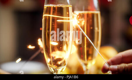 Image Gros plan de deux cierges derrière verres de champagne Banque D'Images