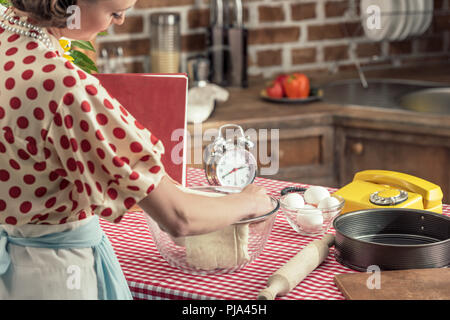 Belle femme au foyer adultes préparer la pâte dans le bol en verre à cuisine Banque D'Images