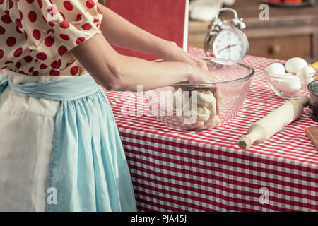Cropped shot de femme au foyer la préparation de la pâte dans le bol en verre à cuisine Banque D'Images