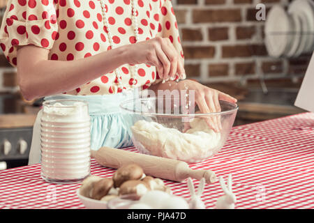 Cropped shot de femme au foyer de répandre de la farine sur la pâte en boule avec cuisine Banque D'Images
