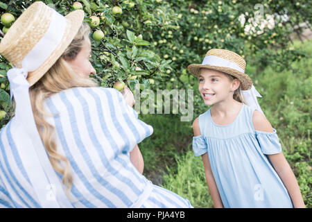 Belle Mère et fille souriante ramasser les pommes vertes ensemble Banque D'Images