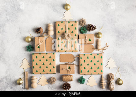 Concept de Noël, arbre de Noël composé de Brown présente des boîtes, des cônes de pin, babioles d'or, des arcs, de la ficelle de jute, objets en bois sur la lumière backgrou Banque D'Images