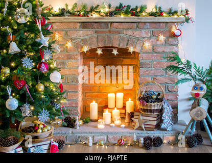 Contexte : configuration de Noël arbre de Noël décoré, des pommes de pin dans le panier avec une cheminée sur l'arrière-plan ; Bougies boules, d'un foc sélective Banque D'Images