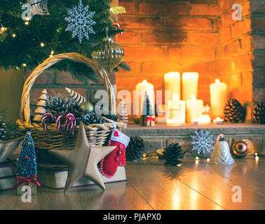 Contexte : configuration de Noël étoile en bois en face de l'arbre de Noël décoré, des pommes de pin dans le panier, les arbres en bois, avec cheminée sur le backgrou Banque D'Images