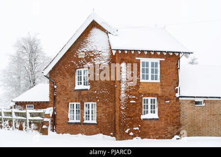 Ancienne maison victorienne avec toit et murs en brique recouverts de neige en hiver Banque D'Images