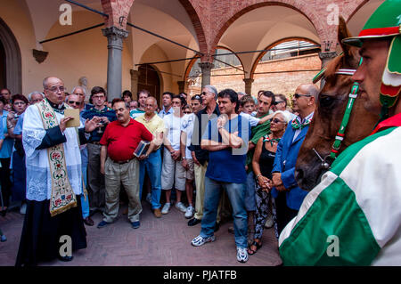 La Contrada prêtre procède à la bénédiction des chevaux Cérémonie, Oca (OIE) Via District, le Palio di Siena, Sienne, Italie Banque D'Images