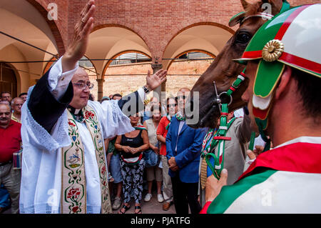 La Contrada prêtre procède à la bénédiction des chevaux Cérémonie, Oca (OIE) Via District, le Palio di Siena, Sienne, Italie Banque D'Images