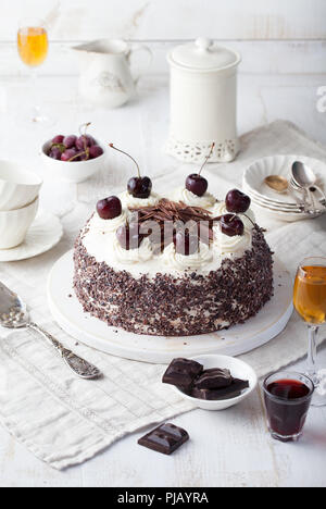 Gâteau Forêt-Noire, Schwarzwald pie, chocolat noir et cerises dessert sur une planche à découper en bois blanc. Banque D'Images