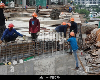 Les travailleurs de la construction de l'installation de la barre de renfort sur le chantier de construction. La barre de renfort est l'élément principal pour le renforcement du béton. Banque D'Images