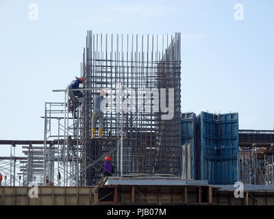 Les travailleurs de la construction de l'installation de la barre de renfort sur le chantier de construction. La barre de renfort est l'élément principal pour le renforcement du béton. Banque D'Images